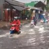 Genangan banjir setinggi betis orang dewasa menutup Jalan KH Fudholi, Karang Asih, Cikarang Utara, Kabupaten Bekasi, membuat pengendara motor terpaksa mendorong kendaraannya, Kamis (29/1/2026).
