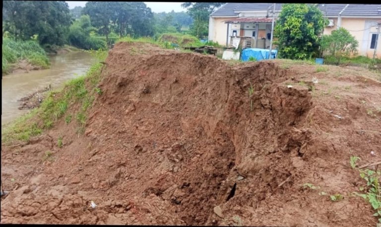 Saluran drainase di Blok R Grand Cikarang Village ambruk dan menyisakan lubang di sisi jalan lingkungan, memicu kekhawatiran warga soal keselamatan.