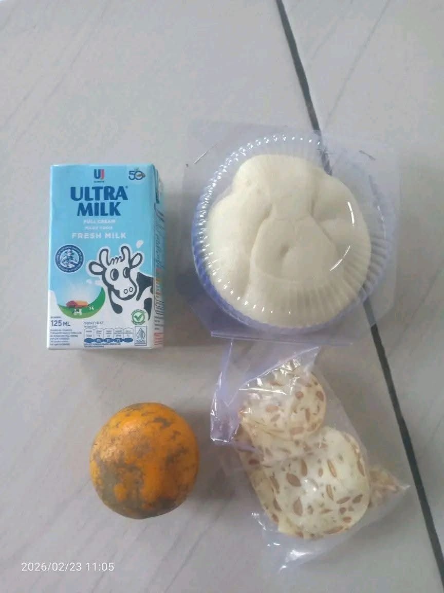 Menu Makan Bergizi Gratis (MBG) berupa roti, susu, keripik tempe, dan jeruk yang dibagikan kepada siswa SDN Karangpatri 04 Pebayuran, Kabupaten Bekasi, Senin (23/2/2026).