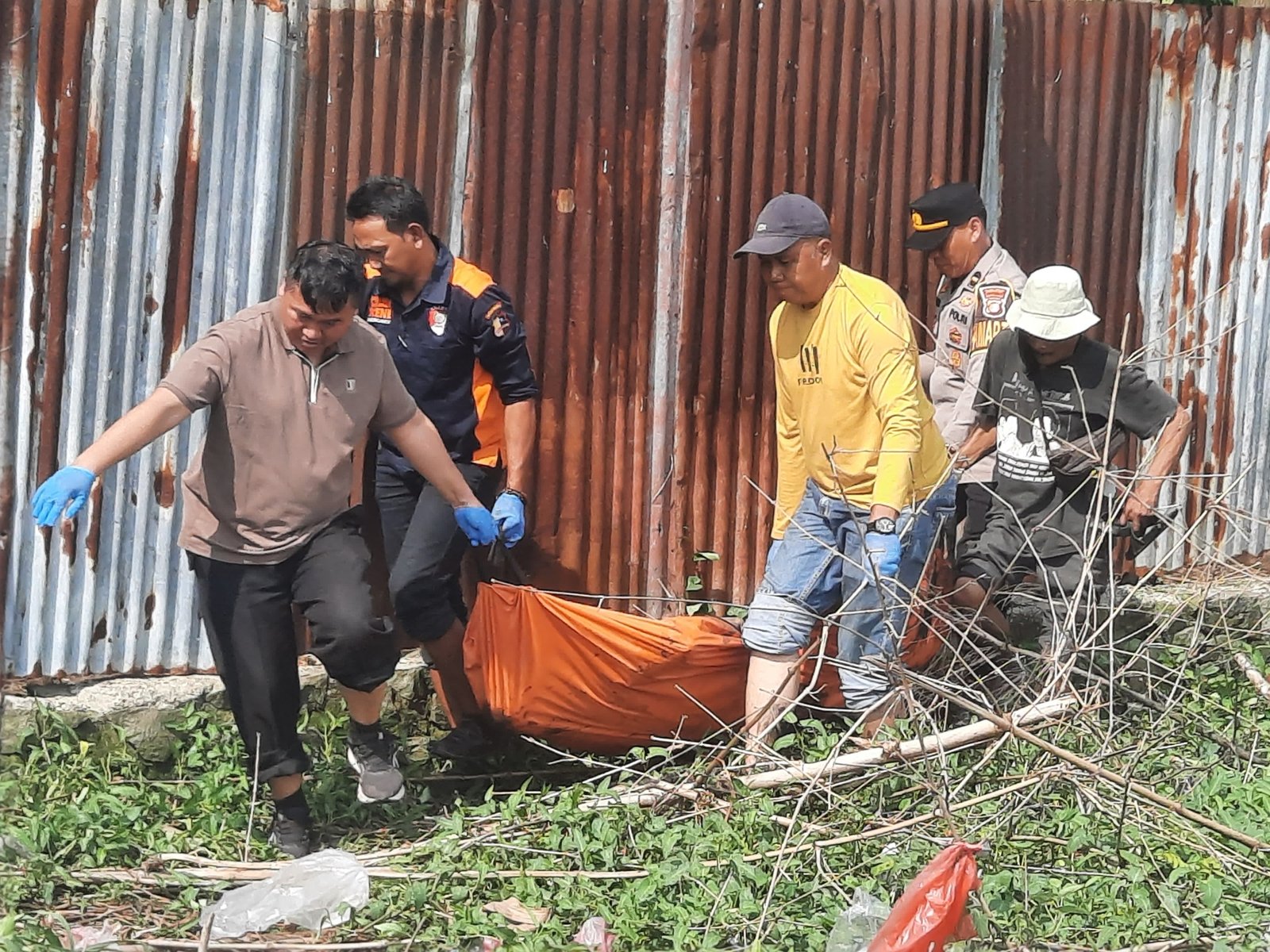 Petugas mengevakuasi jasad pria paruh baya yang ditemukan di area persawahan Karangbahagia, Bekasi.