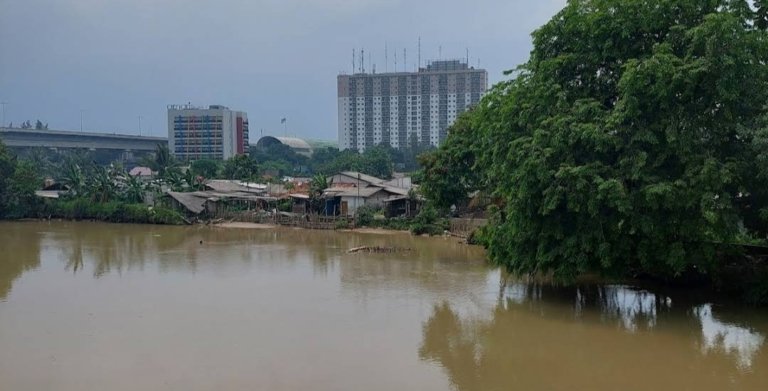Warga memadati bantaran Kali Bekasi di Kampung Baru, Desa Kedung Pengawas, Babelan, setelah ditemukan sesosok jasad pria mengambang di aliran sungai, Jumat (12/6/2026).
