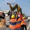 Petugas Dinas Perhubungan Kabupaten Bekasi mengevakuasi tiang PJU yang roboh usai ditabrak truk di Jalan Inspeksi Kalimalang, Desa Gandasari, Kecamatan Cikarang Barat.