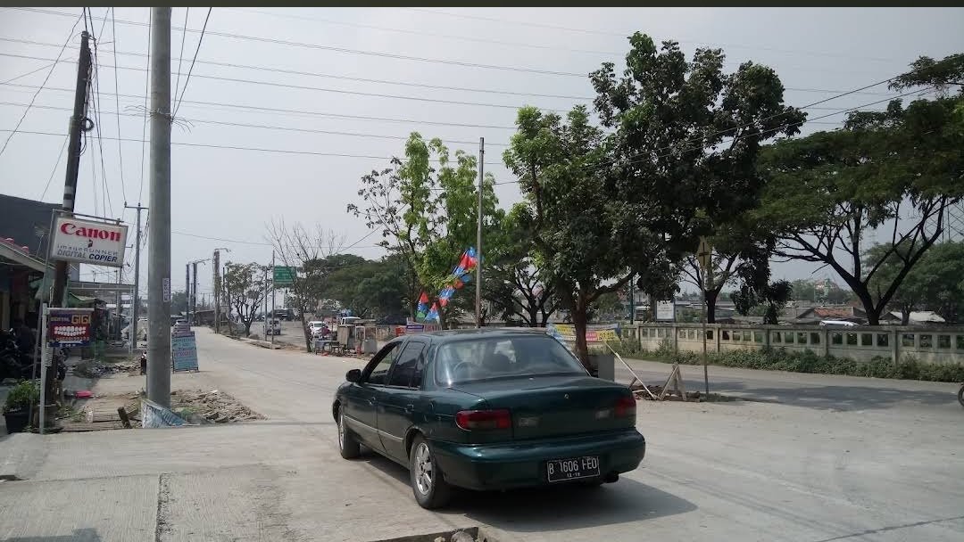 Kondisi ruas jalan di Kampung Tegal Danas, Desa Hegarmukti, Cikarang Pusat, yang dipenuhi debu dan ceceran material beton diduga berasal dari aktivitas truk molen pengangkut beton.