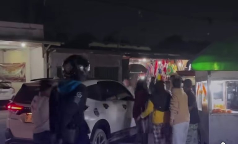 Tangkapan layar video yang memperlihatkan perselisihan antara pengendara motor dan pengemudi mobil di jalan. Dalam kejadian tersebut, seorang pemotor diduga membawa senjata tajam.