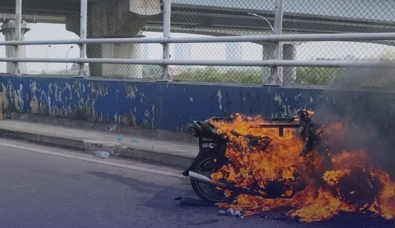 Sebuah motor dengan bak di samping terbakar di kawasan Jembatan Meikarta, Minggu (16/8/2026). Penyebab kebakaran masih belum diketahui.