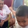 Seorang bocah tampak serius mengikuti lomba 17 Agustus dengan tantangan memasukkan sedotan ke dalam botol menggunakan kaca spion.
